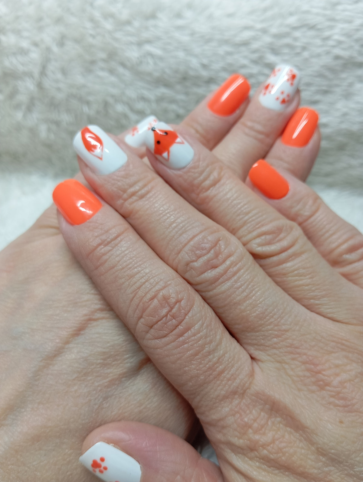 Press-on nails Petit Renard orange corail et blancs portés sur les deux mains