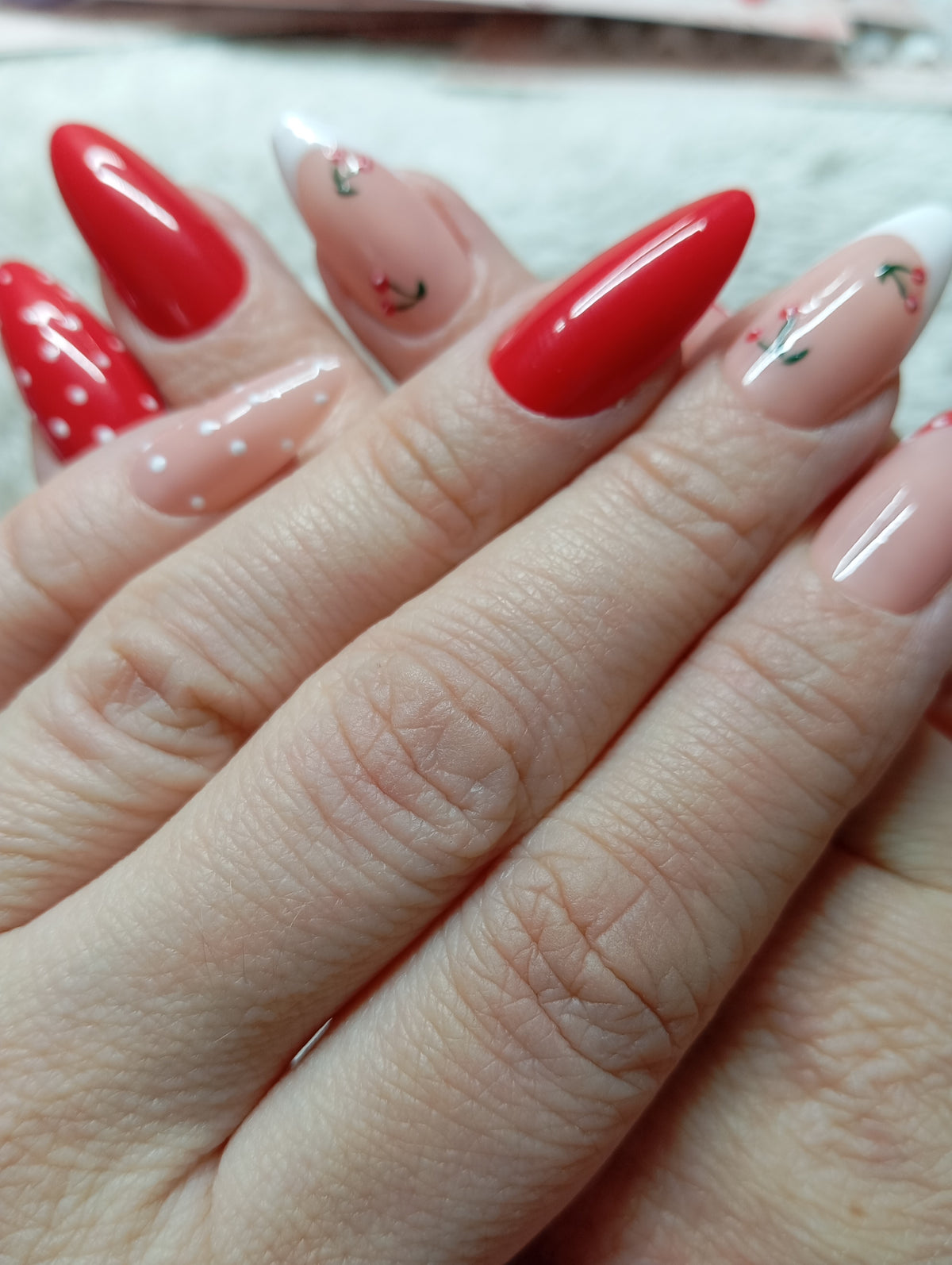 Manucure press-on nails rouge et nude avec cerises, pois blancs et french