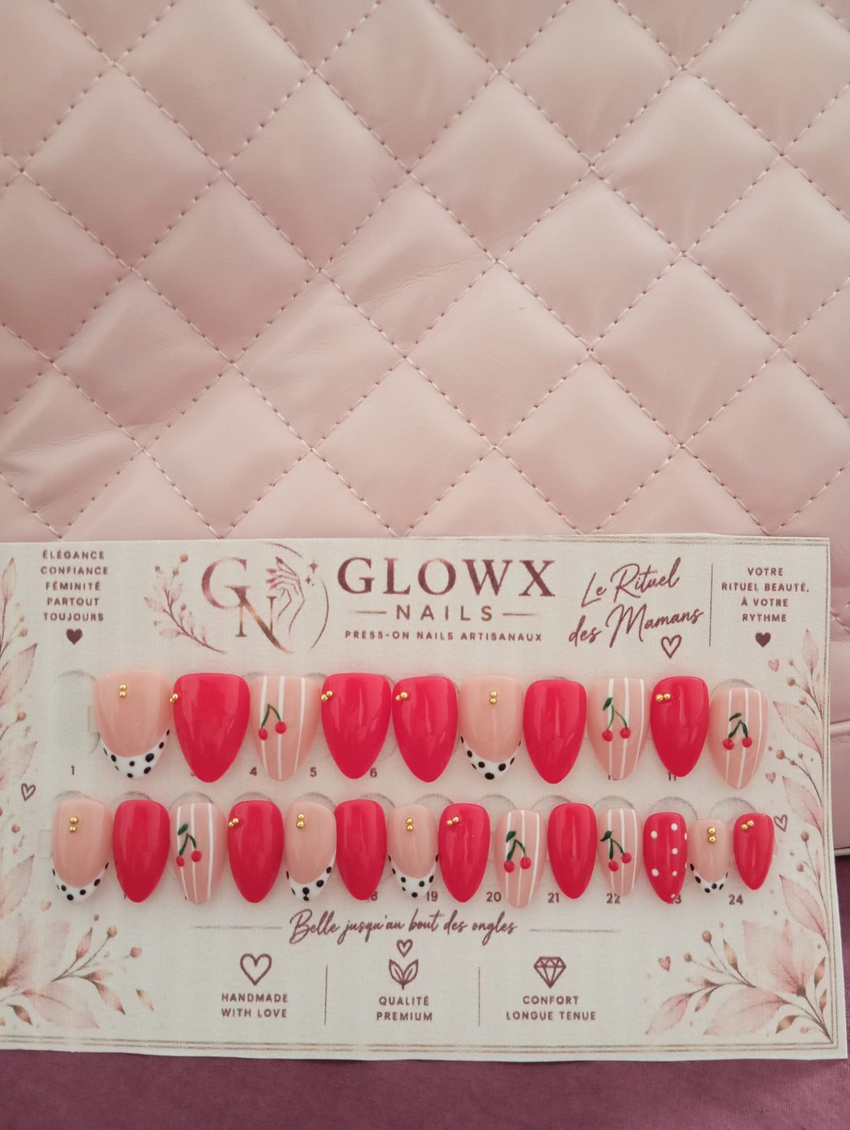 Manucure press-on nails rouge cerise et nude en forme amande portée sur les deux mains